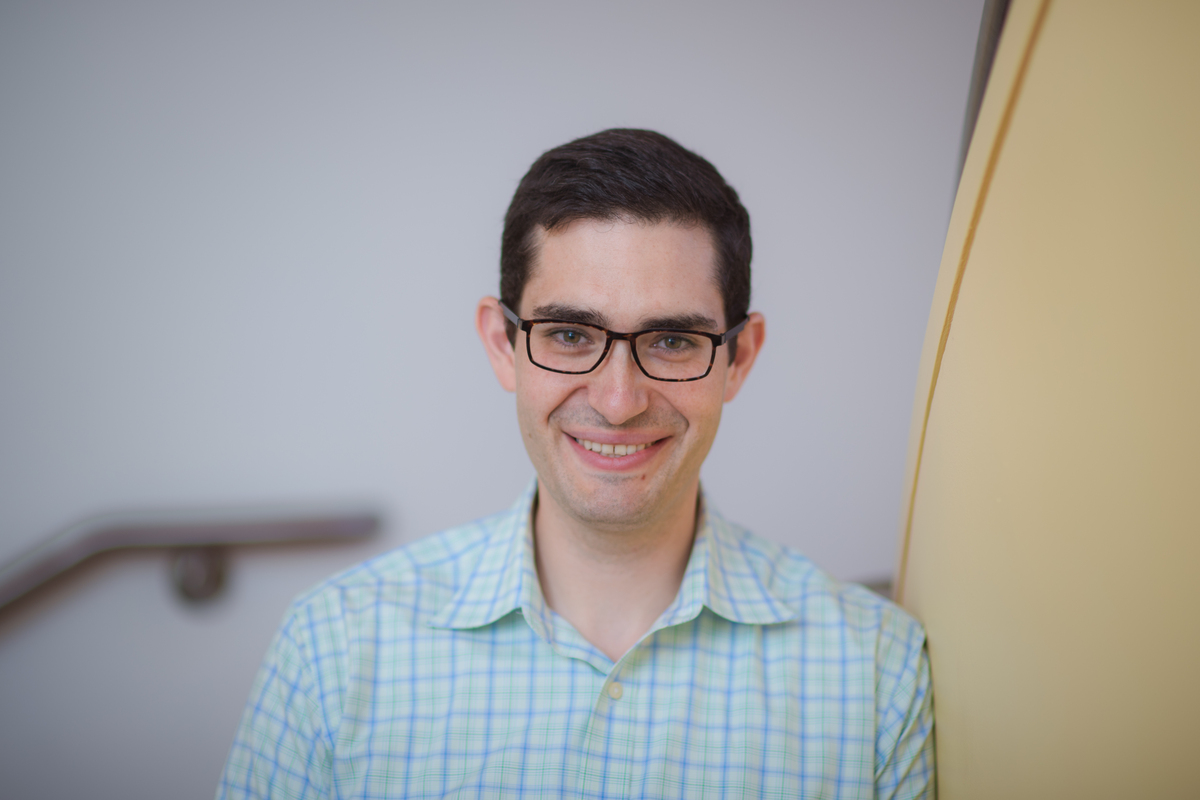 Headshot of a man in a plaid shirt.