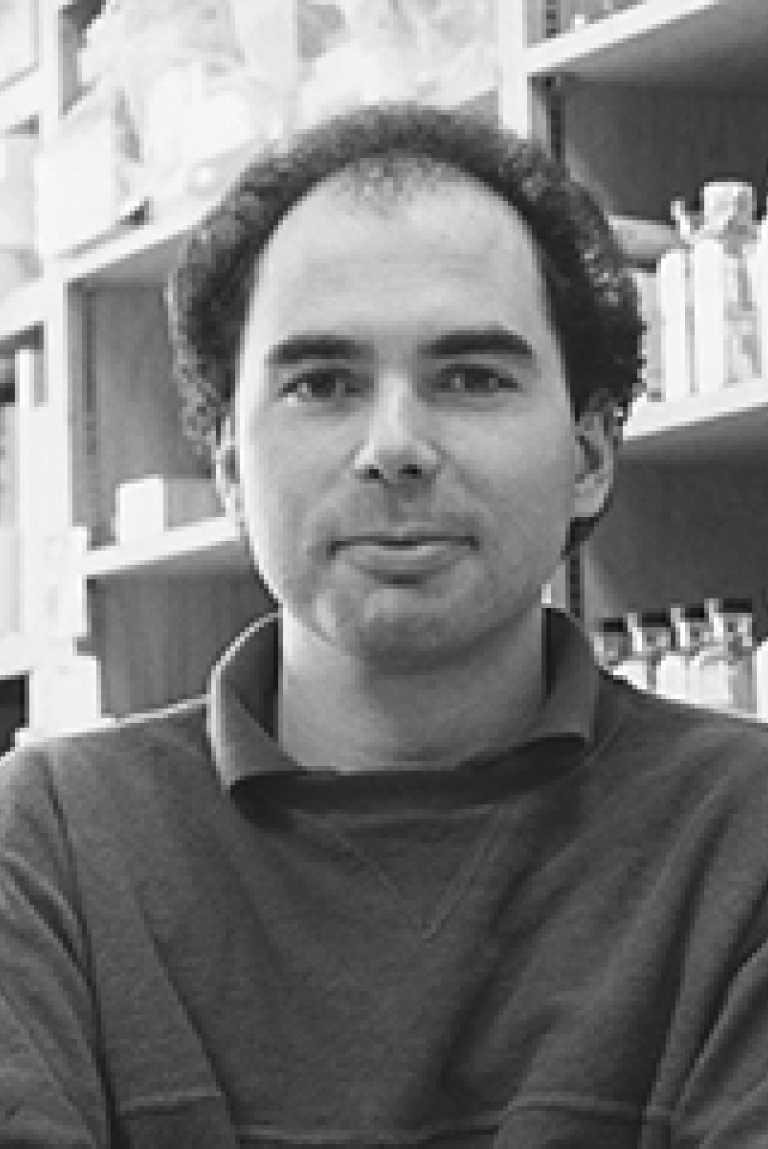 A man in a polo shirt stands in a lab.